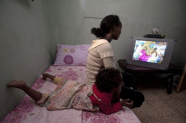 A woman and her daughter watch a wedding DVD, at their room in a building, home to dozens of Eritrean asylum seekers, which was set on fire by a local resident one early morning in Jerusalem. Four Eri...