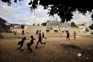 Youth play soccer near their temporary shelter, where they live amongst an Eritrean asylum seeker community.