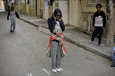 Children play in a street next to their temporary shelter, where they live amongst an Eritrean asylum seeker community.