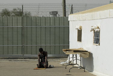 A Muslim detainee prays in a special detention facility within Ketziot Prison compound, designated for African asylum seekers who have illegally crossed the nearby Egyptian-Israeli border.