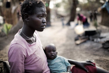 A woman, recently arrived at Doro refugee camp, sits with her baby, both exhausted after making a long journey. More than 500,000 people have fled from Sudan into South Sudan as a result of the ongoin...