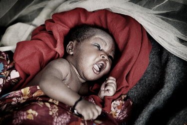 21 day old Dhadhani, the fifth child of Toma Nimiir, born in Jammam refugee camp. The family were forced to flee their home, a seven day walk away in Sudan, after the area they lived in was bombed wit...