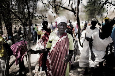 A woman stands with a crowd in a brushwood thicket at Sunday mass in Doro refugee camp. More than 500,000 people have fled from Sudan into South Sudan as a result of the ongoing conflict between the t...