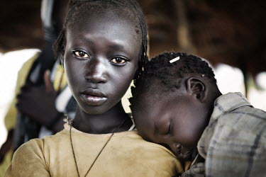 A child sleeps on the shoulder of an older girl in the Jammam refugee camp.