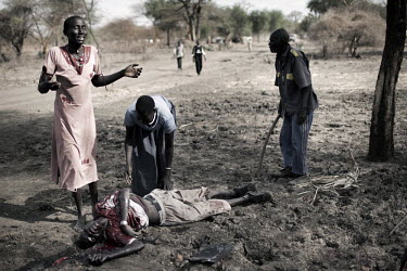 The wife of a man stabbed to death with a spear, cries beside his bloodied corpse in Doro refugee camp. The death was the result of an inter-tribal conflict, one of many assaults and murders occuring...