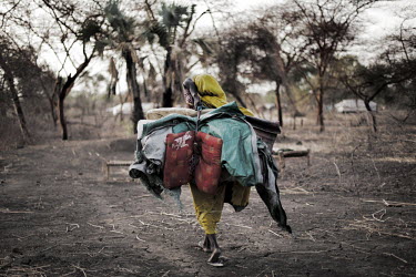 A woman arrives at Jammam refugee camp, loaded down with as much as she could carry when she fled her home. More than 500,000 people have fled from Sudan into South Sudan as a result of the ongoing co...