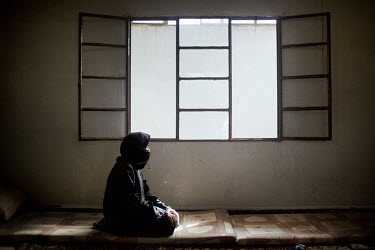 A woman sits in an apartment that she shares with six women and six children who all fled from the conflict raging in their homeland. They pay 120 GBP each month in rent, which is raised by one of the...