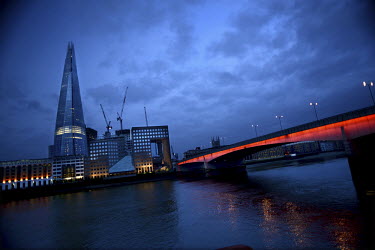 A view from the north side of the River Thames south to London Bridge, illuminated in Red, and the Shard rising 310 metres in the centre.