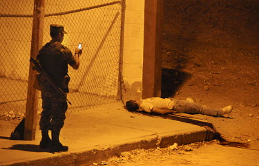 A member of the army takes a photograph of a murder victim, probably related to drug trafficking. Ciudad Juarez is the most violent city in Mexico and the epicentre of the war on drugs. 2000 people we...