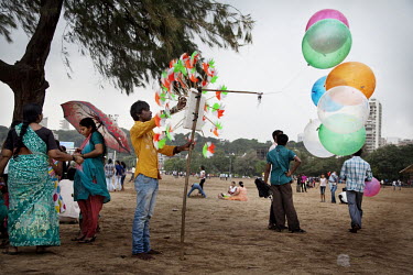 A vendor sells balloons and pinwheels at the popular Chowpatty beach which is loaded with working and middle class Indians on a national holiday weekend.