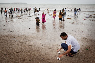 A man collects his daughter's shoes along Chowpatty beach, a popular hangout for working and middle class Indians.