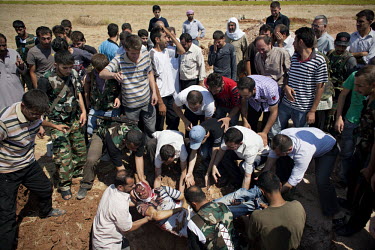 Free Syrian Army (FSA) fighters and family members bury the body of Omar Ismail Abdul Rahman (30) who died fighting for the FSA in Salaheddin, Aleppo, at his funeral in Tal Rifaat. Omar, a farm boy fr...