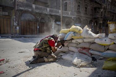A rebel Free Syrian Army (FSA) fighter fires on a Syrian Army position 200m down an alley in the old city area of Aleppo.
