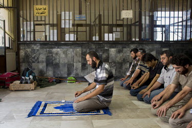 32 year old Hajji Mari (AKA Abdul Qadr Saleh) the military commander of the Free Syrian Army's Unity Brigade that took Aleppo prays in a telephone exchange, that the FSA was using as a command centre,...