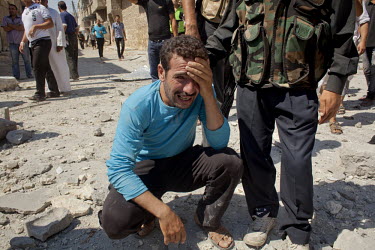 A man reacts moments after his home was destroyed and family members killed by two bombs dropped from Syrian Airforce fighter jets that were targeting the neighbouring Free Syrian Army (FSA) command c...