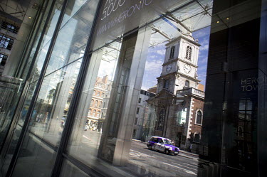 The church of St Botolph without Bishopsgate is reflected in the glass of Heron Tower, 110 Bishopsgate, City of London. Heron tower was, in 2012, London's second tallest building, rising 242 metres ov...