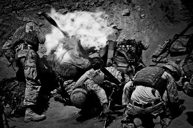 U.S. Marines evade the back blast after firing a mortar from Safar military base in the Safaar Bazar District of Helmand Province.