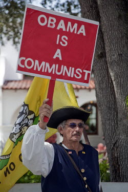 A Tea Party activist carrying a placard that reads: 'Obama is a Communist' during a rally in St. Augustine, Florida. This local chapter of the Tea Party has fallen out with the Republicans who want th...