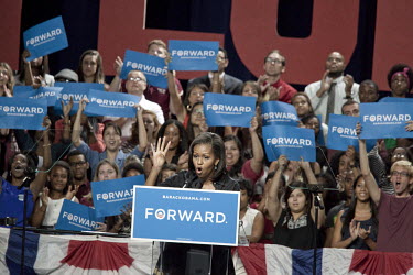 Students from Florida State University and Florida A&M University wave and cheer behind Michele Obama as she speaks at a rally for her husband in Tallahassee, Florida. She holds up four fingers signif...
