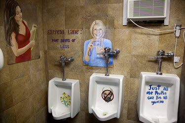 A picture of Osama Bin Laden painted on a men's urinal in a bar in Florida, along with other images painted onto the wall.