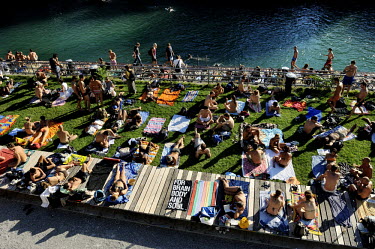 People relaxing at Oberen Letten bathing spot on the River Letten close to the centre of Zurich. This fashionable spot, complete with bars and cafes is a symbol of urban regeneration, as before a majo...