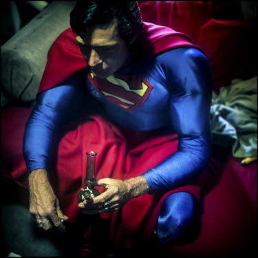 45 year old Christopher Dennis wears a Superman costume in his apartment. He has been entertaining tourists on Hollywood boulevard, posing for photographs with them for the last 19 years.