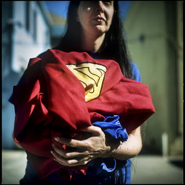 45 year old Christopher Dennis' wife Bonnie prepares to wash his costume. Christopher works as a Superman impersonator on Hollywood Boulevard. He has been entertaining tourists, posing for photographs...