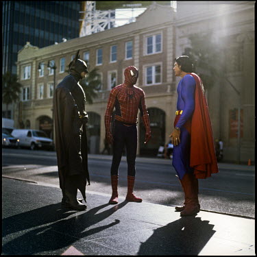 45 year old Christopher Dennis wears a Superman costume on Hollywood Boulevard as he talks with others dressed as Batman and Spiderman. He has been entertaining tourists, posing for photographs with t...