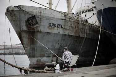 A man is fishing near to the abandoned ship Shkval, one of the ships of the former Soviet fleet, aground in Puerta de la Luz.After the fall of the Soviet Union in 1991, its enormous fleet of fishing s...