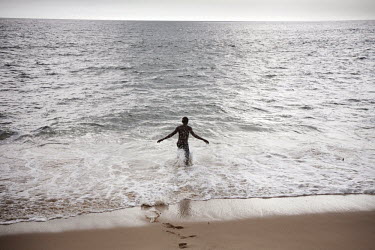16 year old Abdul Sesay enjoys his freedom as he runs into the ocean to swim. Abdul has spent the last five years on the streets with time in jail but he is now living at the Saint Michael  rehabilita...