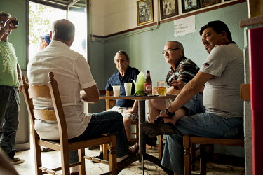 Workers from the Ilva Steel plant drink beer and play cards in a bar in the centre of the Tamburi district.