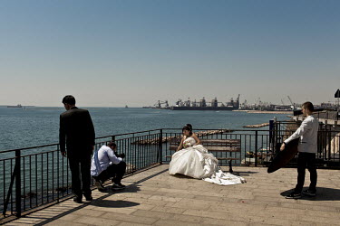 A couple have their wedding photos taken along the sea front in Taranto. The docks and steel plant are seen to many as huge success stories. The town has little or no tourism, no agriculture and  no l...