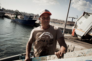 Giovani, a mussel fisherman in the bay of Taranto watches on as his morning harvest of mussels is loaded onto the quayside and then destroyed.  The mussels that are grown in the sea are deemed too tox...