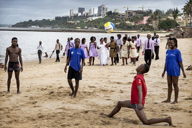 Young men play volleyball on a beach in Maputo with new residential buildings under construction in the background. Mozambique's economy is one of the fastest growing due to foreign investment and the...