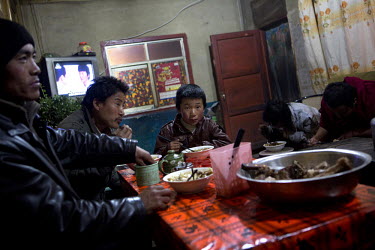 A group of ethnic Tibetans eating a meal in a restaurant in Jiamu Guan Village.