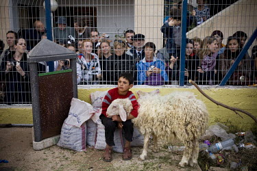 A Samaritan boy holds on to a sheep before it is slaughtered as tourists gather to watch the annual Passover Sacrifice. Approximately 700 Samaritans live in Israel, mostly in Mount Gerizim in the West...