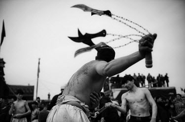 A man self-flagellates with sharpened blades during Ashura, the last day of Muharram. Ashura is observed by Shi'a (Shiite) Muslims at the end of a period of mourning for the martyrdom of Hussein ibn A...