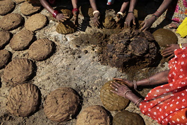Women have collected buffalo dung and turn it into pancakes in order to dry it and then use it as a fuel for cooking.