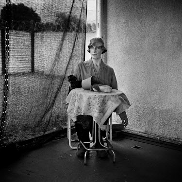 A mannequin sits at a table.