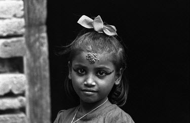 A young girl with a tikalteeka, a mixture of abir (red powder dye), yoghurt and grains of rice applied by a priest as a blessing, on her forehead.