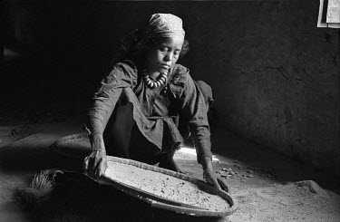 A woman winnowing rice.