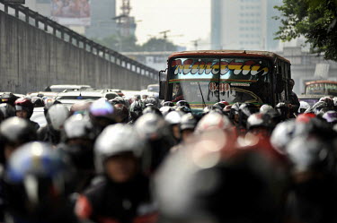 A bus and sea of motorcyclists queue up at a busy junction of the Toll Road in south-central Jakarta in the morning. With 10-plus million people living in the capital - 25 million, if the Greater Metr...