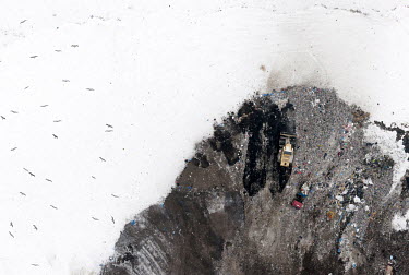 Eko Dolina (Eko Valley company) garbage landfill near the city of Gdynia, covered in snow. Birds fly above.