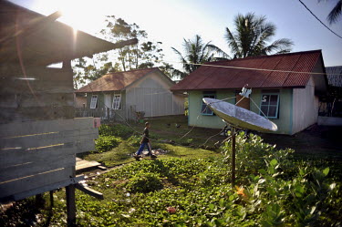 A young boy walks towards his house in Syiakuala Village, one of many homes erected all along the coast to replace those that were destroyed by the 26 December 2004 tsunami. Following a peace deal wit...