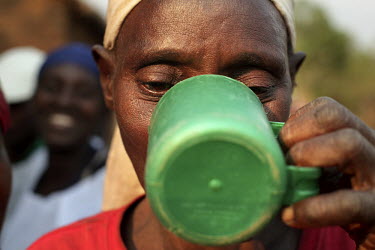 Francine Nibitangavyose drinks a cup of water while she takes tablets that contain medicines that combat the neglected tropical diseases prevalent in the area she lives. In every village of Bururi, Ru...