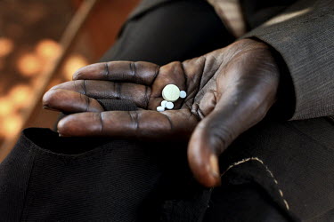 A man holds some tablets in his hand. These contain some of the drugs he needs to take in order to combat a number of so-called 'neglected tropical diseases' common in the area. In every village of Bu...