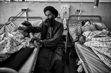 A man comforts one of two men injured during a Taliban attack, that they claimed was in  revenge for the killing of Osama bin Laden, as they are treated at Mirvays Hospital.