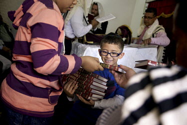 A boy collects prayer books after the service at a synagogue. recites prayers in a synagogue. They belong to a community, one of many worldwide, of so-called 'lost Jews'. These communities, often prev...