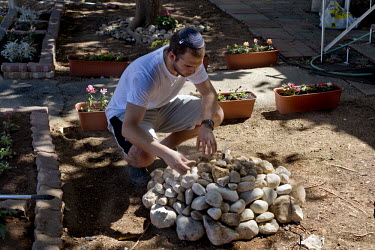 An American student wearing a skull cap arranges a fountain with stones at the Sha'alvim kibbutz.