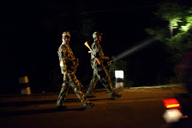 Central Reserve Police Force (CRPF) policemen on night patrol are seen out the window of a moving vehicle in Dantewada.
